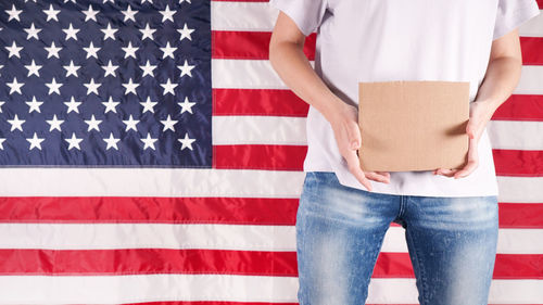 Midsection of man holding american flag