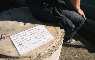 Low section of man sitting on street