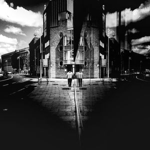 Buildings in city against cloudy sky