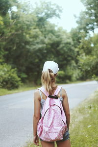 Rear view of a girl standing on country road