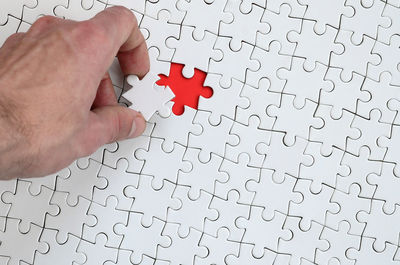 Close-up of human hand playing jigsaw puzzle