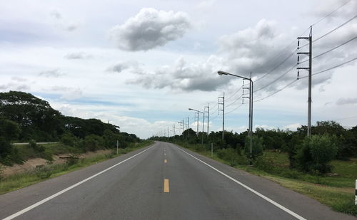 Road amidst trees against sky