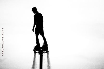 Low angle view of silhouette man walking against clear sky