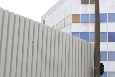 Close-up of fence against modern building 