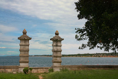 Built structure by sea against sky