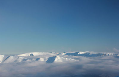 Scenic view of snowcapped mountains against blue sky