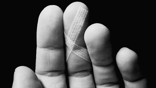 Close-up of hands against black background