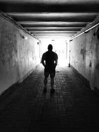 Rear view of man standing in tunnel