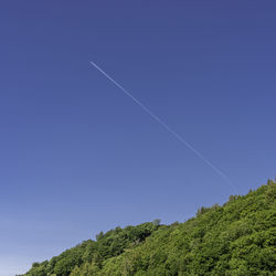 Low angle view of vapor trail against blue sky