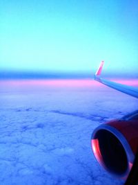 Close-up of airplane wing against blue sky