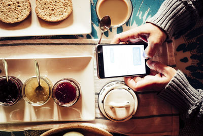 Midsection of woman holding coffee cup on table