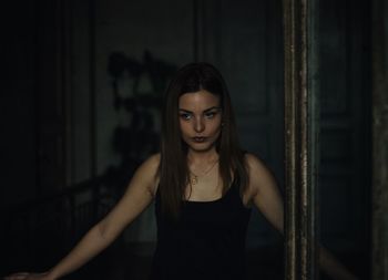 Woman looking away while standing in darkroom