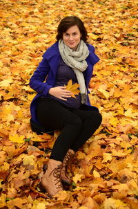 Portrait of smiling young woman with autumn leaves