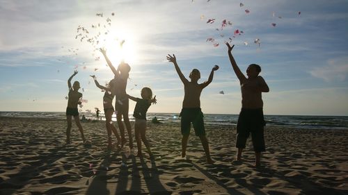 People at beach against sky