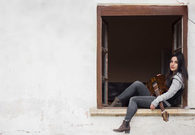 Full length portrait of woman sitting outdoors