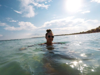 Portrait of woman swimming in sea against sky