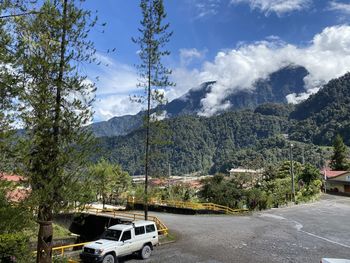 Cars on road by mountains against sky