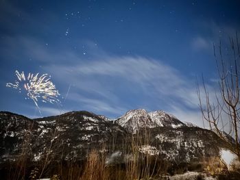 Low angle view of snowcapped mountains against sky at night