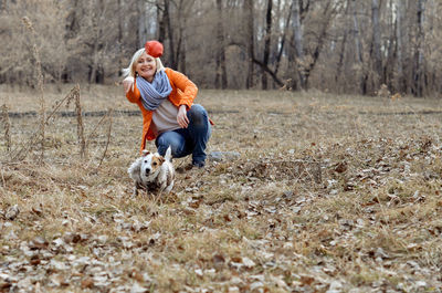Cheerful girl playing with a dog in the park. jack russell is in a leap.