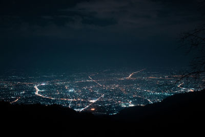 Illuminated cityscape against sky at night