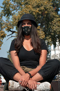 Portrait of young woman sitting in park