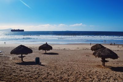 Scenic view of beach against blue sky