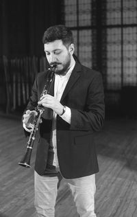 Man playing clarinet while standing at studio