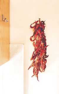 Close-up of red chili peppers against wall