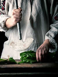 Midsection of woman cutting vegetables on cutting board