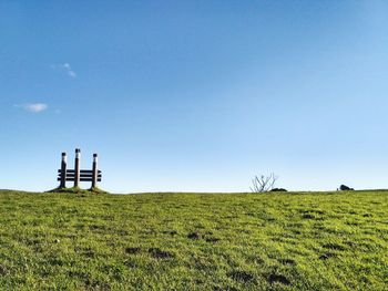 Windmills on field against clear sky