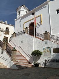 Potted plant by staircase outside building against sky