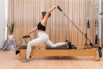 Side view of woman sitting on wooden floor