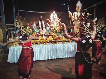 People in traditional clothing standing at night