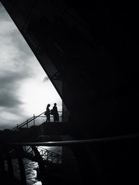 Low angle view of people standing on bridge