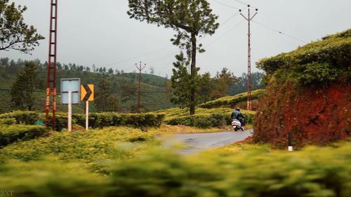 People riding motorcycle on road against sky