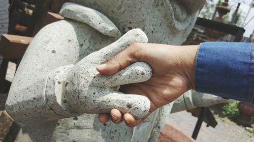 Cropped hand holding statue