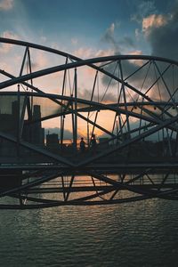 Bridge over river against sky during sunset