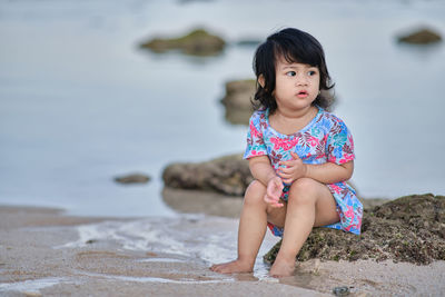 Portrait of cute girl sitting on land