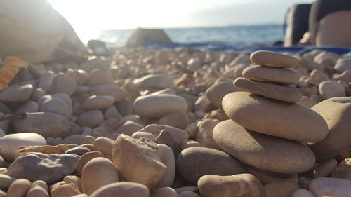 Pebble stones at beach against sea and sky