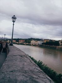 Street by river against sky in city