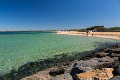 Tourists on beach against sky