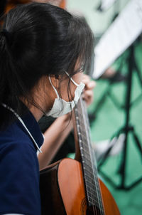 Woman in mask playing guitar