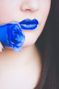 Cropped image of woman with blue rose