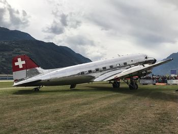 Airplane on airport runway against sky