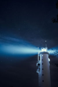 Lighthouse against sky at night