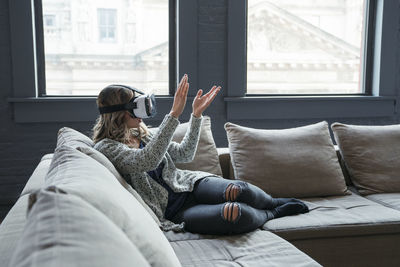 Businesswoman wearing virtual reality simulator clapping in office