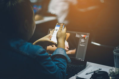 Woman using laptop computer at desk in office