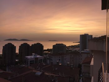 High angle view of buildings against cloudy sky during sunset