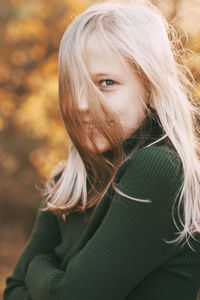 Portrait of a beautiful teenage girl with blond hair and blue eyes with a smile on her face 