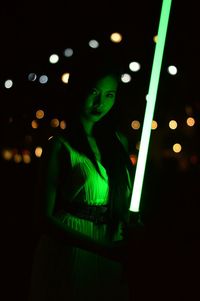 Full frame shot of illuminated woman against black background